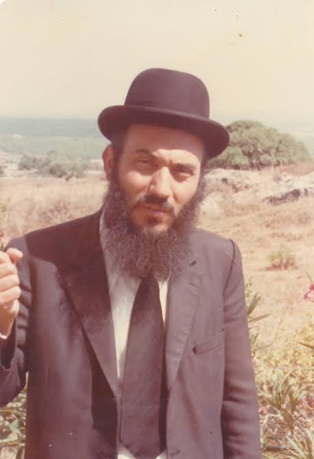 An archival outdoor portrait of Rabbi Nissim Yagen in a black hat and suit